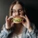 pexels-pavel-danilyuk fille qui mange un hamburger 4 signes que tu es accro à la malbouffe