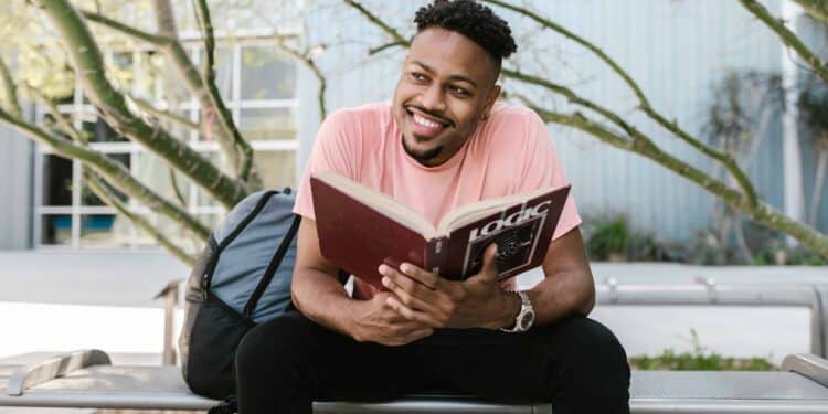 pexels-rodnae-productions-garcon etudiant qui lit un libre dehors - Pourquoi être étudiant.e est le meilleur moment de ta vie