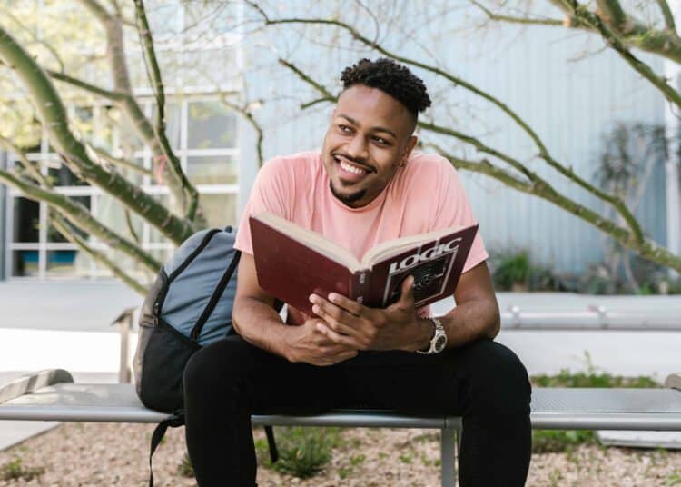 pexels-rodnae-productions-garcon etudiant qui lit un libre dehors - Pourquoi être étudiant.e est le meilleur moment de ta vie