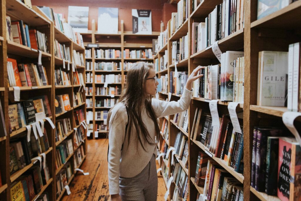 unsplash -becca-tapert-Femme qui cherche à la bibliothèque - Dossier je suis déçu de mes études comment rebondir