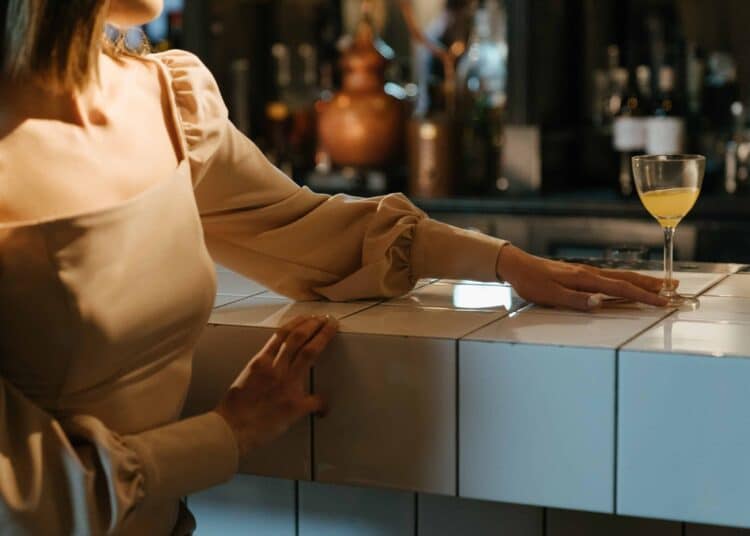 pexels-cottonbro- etudiante qui boit un verre à un bar - Top 10 des excuses pour écourter un rencard