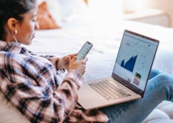 pexels-liza-summer-femme sur son oridnateur et smarthpone - les jeunes plus actifs en bourse, la nouvelle côte ? -