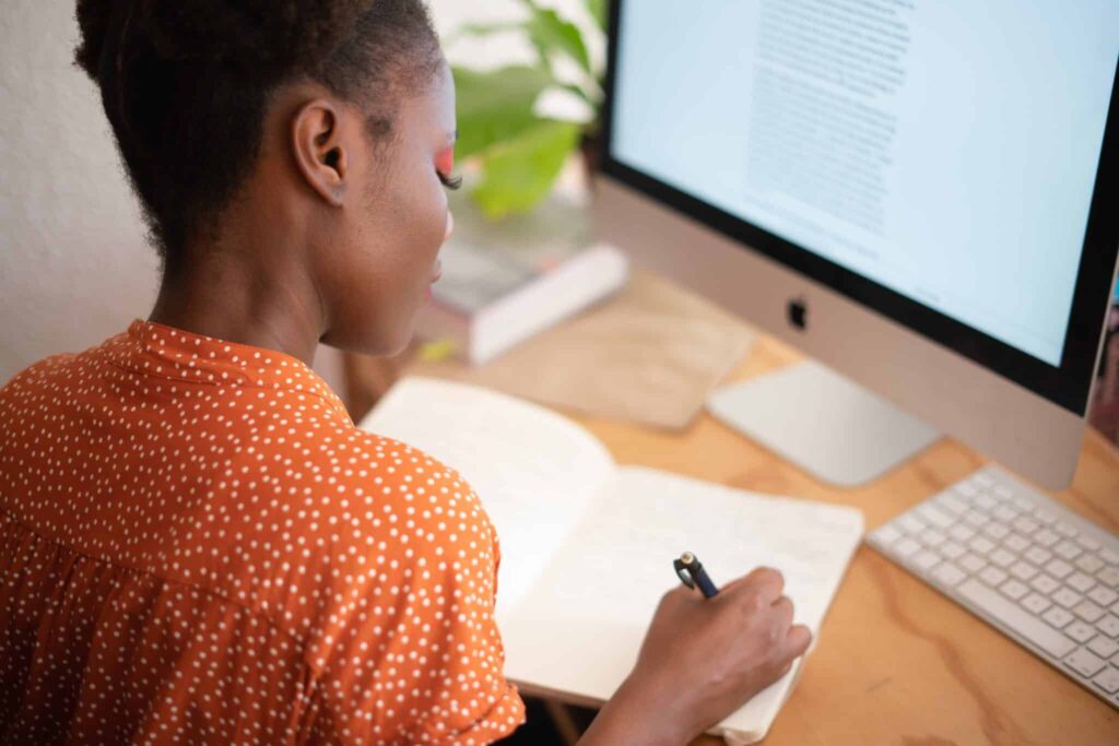 pexels-rfstudio-femme écrit sur son cahier devant son pc- les 5 raisons de devenir étudiant entreprenuer