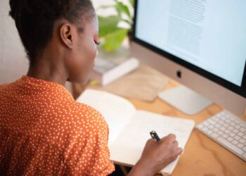 pexels-rfstudio-femme écrit sur son cahier devant son pc- les 5 raisons de devenir étudiant entreprenuer