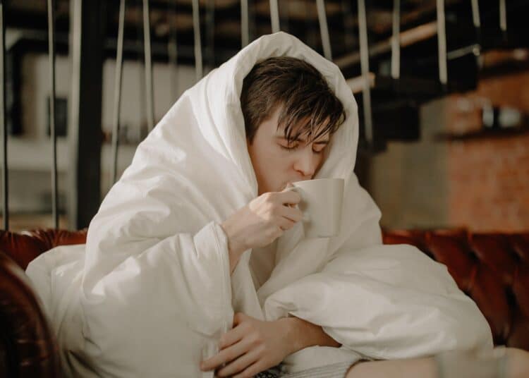 pexels-cottonbrostudio-jeuneenroulédanssacouverturepourseréchauffer-4 astuces pour garder la chaleur dans ton kot et ne pas devoir le chauffer