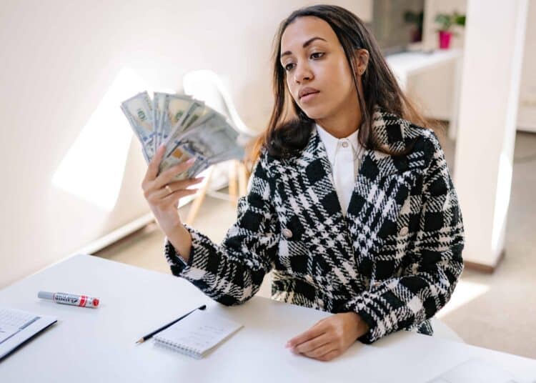 pexels-yan-krukov - étudiante qui compte ses billets d'argent - Top 4 des séries pour vivre une vie de riche