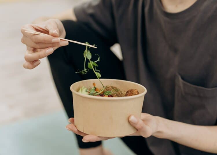 pexels-mikhail-nilov-étudiant qui mange - Comment manger des fruits et légumes plus facilement quand on est étudiant