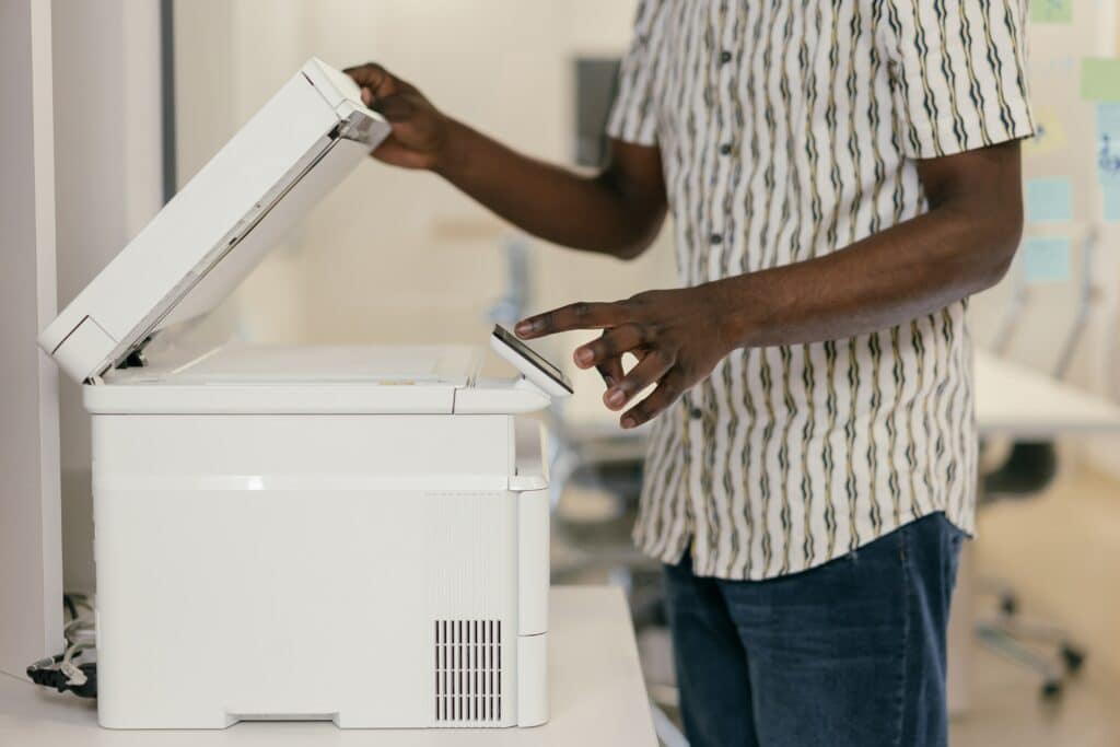 pexels-mikhail-nilov- jeune étudiant qui photocopie - 3 endroits pour imprimer et photocopier tes cours à Louvain-la-neuve