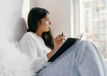 pexels-mikhail-nilov-étudiante qui pense-5 situations où tu regrettes de ne pas vivre en kot