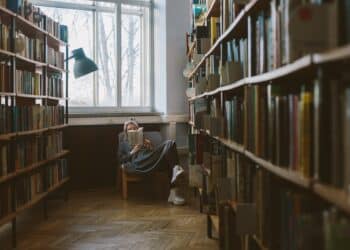 pexels-polina-zimmerman-étudiante qui lit un livre dans une bibliothèque - Les meilleures lectures quand on approche de la rentrée