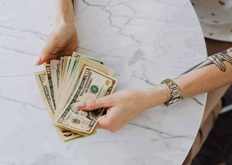 pexels-karolina-grabowska-étudiante qui compte son argent - Comment financer ses études seul.e