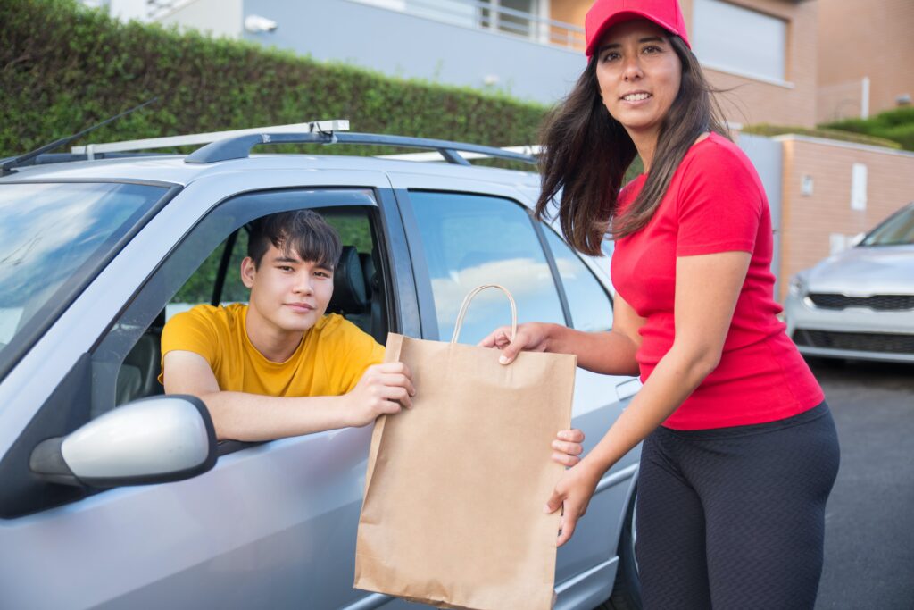 pexels-kampus-production- een vrouw die iets levert aan de man -Enkele redenen waarom online eten bestellen niet goed is voor je portemonnee