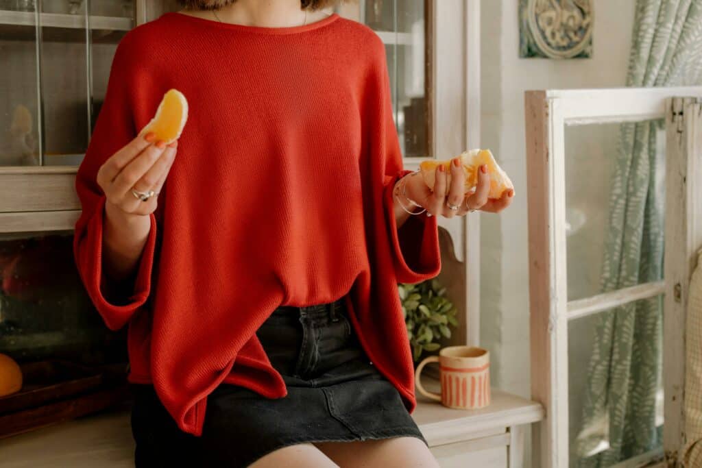 pexels-cottonbro-studio-Femme mangeant une orange-l'importance d'une bonne alimentation durant tes études