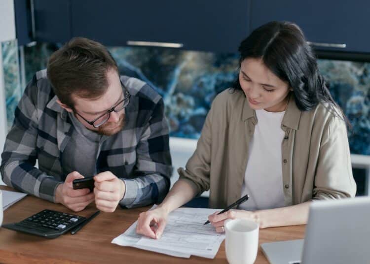 pexels-mikhail-nilov-femme et homme qui regarent un contrat - Les choses à savoir avant de signer ton contrat de kot