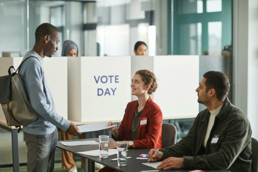 pexels-photo-jeune qui remet son bulletin de vote-Les élections en 2024 Mode d’emploi