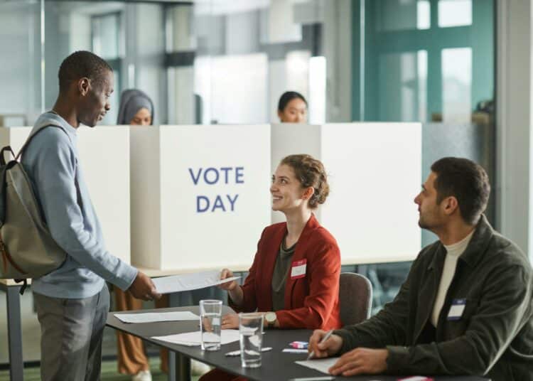 pexels-photo-jeune qui remet son bulletin de vote-Les élections en 2024 Mode d’emploi