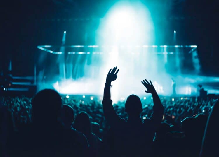 pexels-sebastian-ervi-personne qui lève les bras devant une scène à un festival - 5 artistes à ne pas manquer au festival Pukkelpop 2024