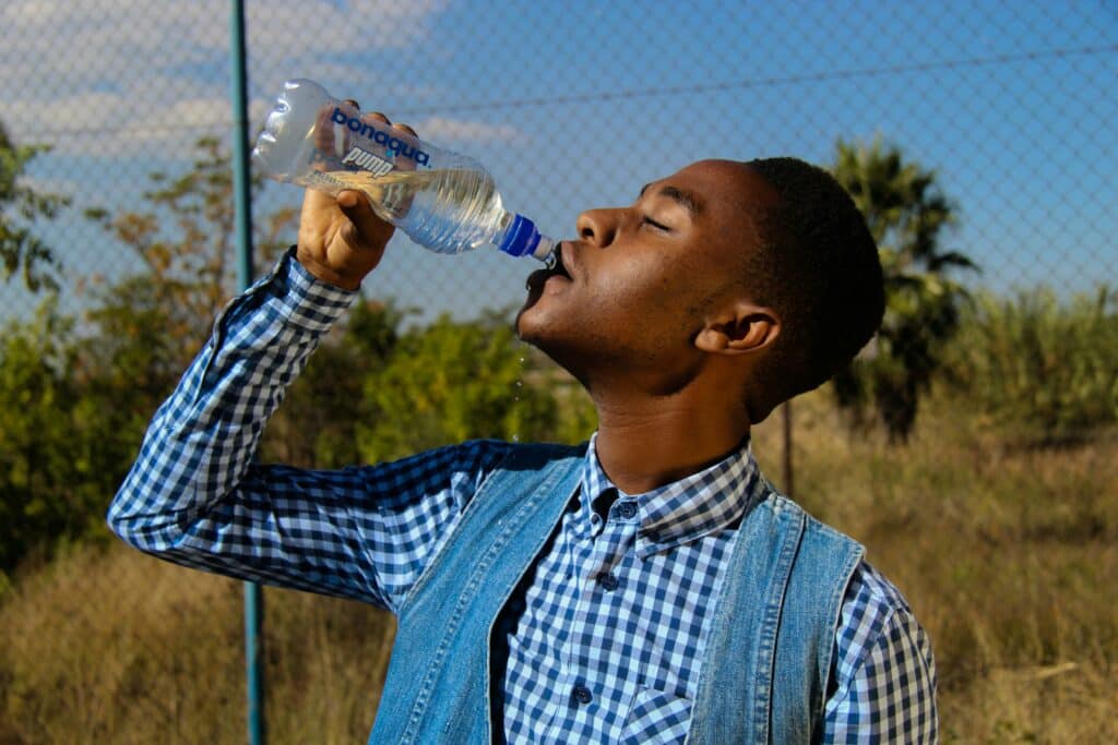 pexels-thomas-chauke-homme boit eau-bois pas assez d’eau, comment faire boire plus ?