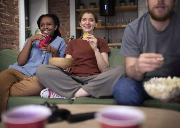 Freepik - Freepik - deux filles et un garçon sur un canapé regardant la tv - Les 6 classiques à voir pour décompresser après un exam