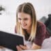 Freepik - freepik - fille qui sourit en regardant sa tablette - 4 séries à binge-watcher après ta session