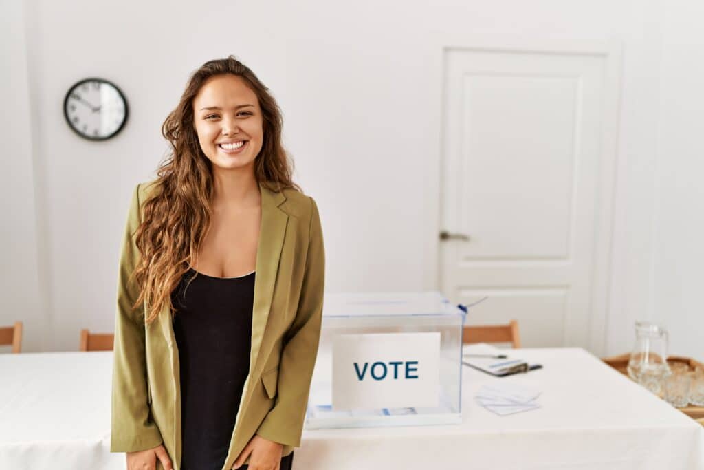 freepik - krakenimages.com - fille qui sourit devant un bureau de votes - Comment fonctionne le vote en Belgique