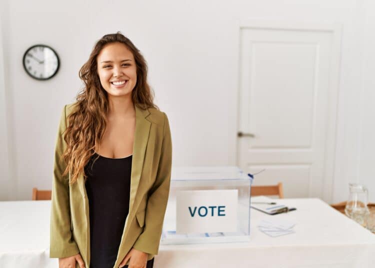 freepik - krakenimages.com - fille qui sourit devant un bureau de votes - Comment fonctionne le vote en Belgique
