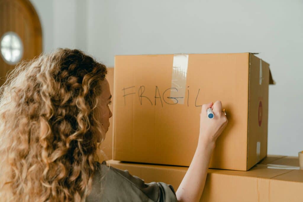 pexels-ketut-subiyanto-fille qui écrit sur des cartons de déménagement-Comment déménager de kot quand on est étudiant