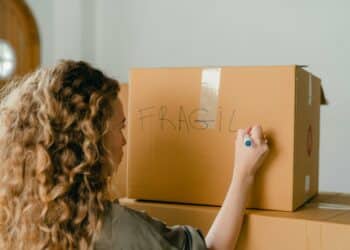 pexels-ketut-subiyanto-fille qui écrit sur des cartons de déménagement-Comment déménager de kot quand on est étudiant