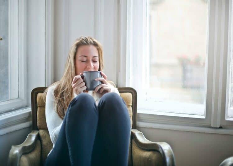 pexels-olly-étudiante qui boit du café-Rester au kot ou chez tes parents pendant les vacances avantages et inconvénients