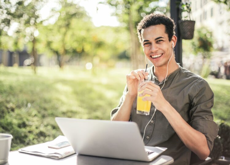 pexels-andrea-piacquadio-étudiant qui travaille sur son pc à l'extérieur avec un verre à la main-Comment profiter de tes vacances tout en étudiant pour ta seconde session