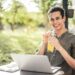 pexels-andrea-piacquadio-étudiant qui travaille sur son pc à l'extérieur avec un verre à la main-Comment profiter de tes vacances tout en étudiant pour ta seconde session