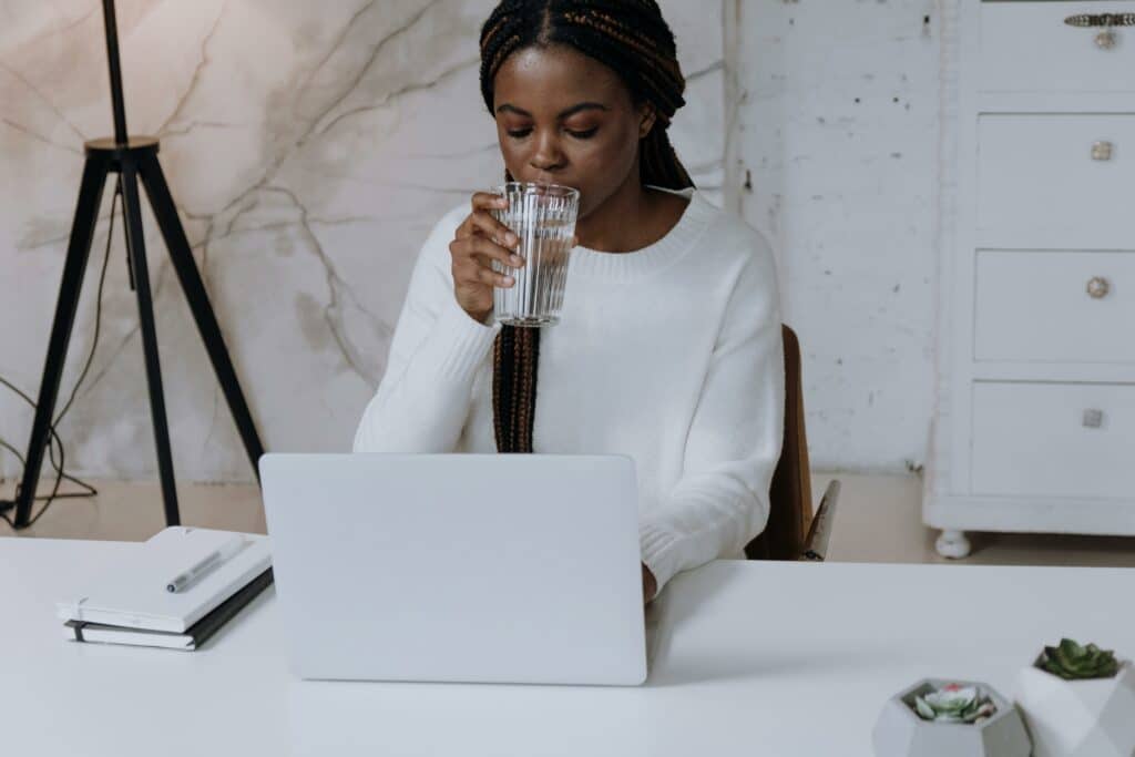 pexels-cottonbro-étudiante sur son ordinateur en train de boire un verre-Comment financer son premier ordinateur portable