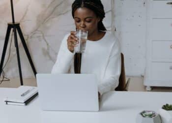 pexels-cottonbro-étudiante sur son ordinateur en train de boire un verre-Comment financer son premier ordinateur portable