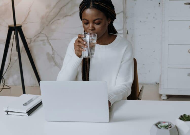 pexels-cottonbro-étudiante sur son ordinateur en train de boire un verre-Comment financer son premier ordinateur portable
