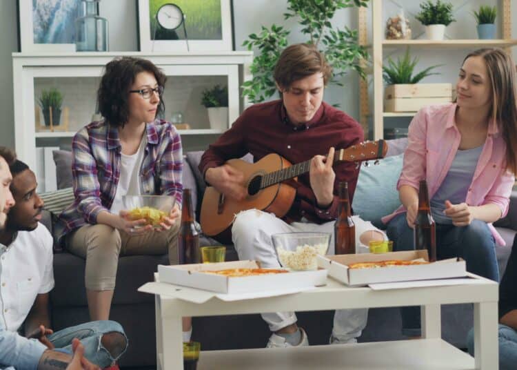 pexels-silverkblack-groupe de colocataire assis sur un divan et joueant de a guitare-7 façons de rendre votre coloc super chouette