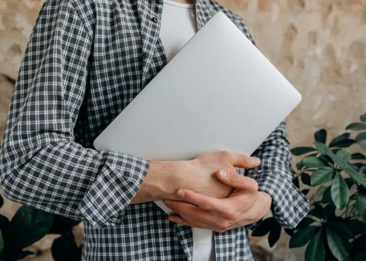 pexels-mikhail-nilov-étudiant qui tient un ordinateur-C’est quoi un minerval