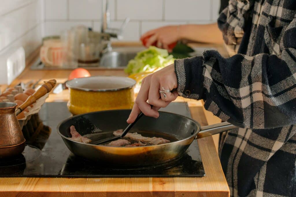 pexels-cottonbro-étudiante qui cuisine avec 3 poêles-4 recettes à faire rapidement en blocus