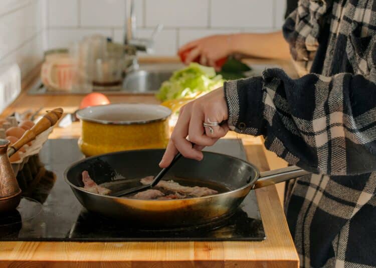 pexels-cottonbro-étudiante qui cuisine avec 3 poêles-4 recettes à faire rapidement en blocus