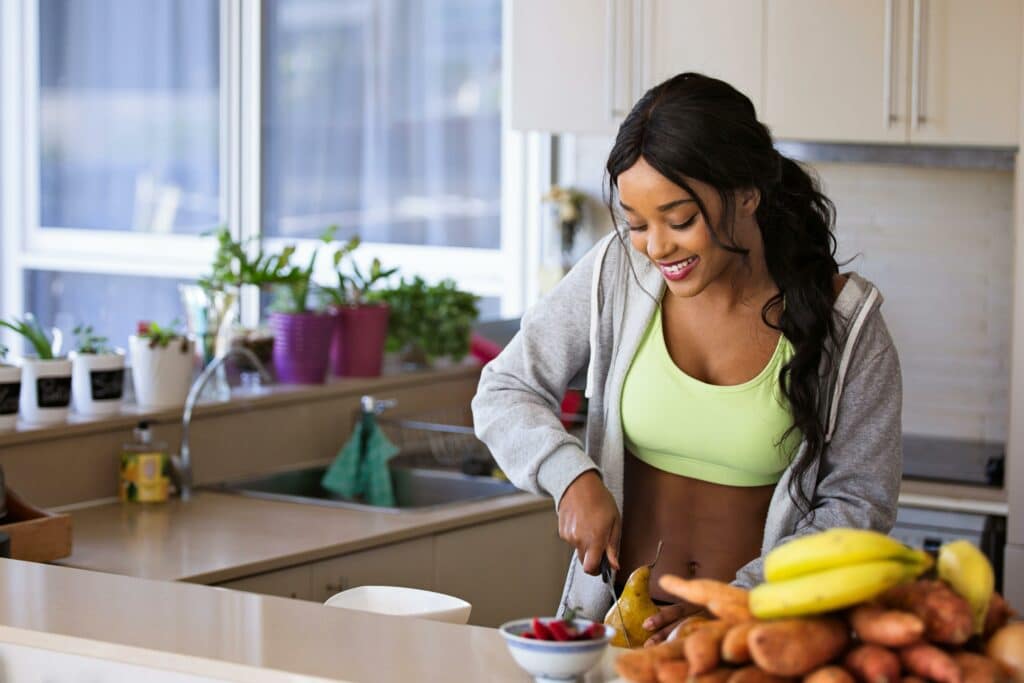 pexels-mastercowley-femme-coupe-fruits-Comment-manger-sainement-avec-un-budget-etudiant--scaled.jpg