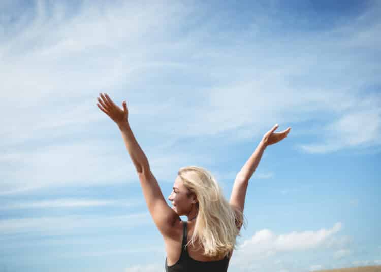 Freepik - femme lève les bras en l'air heureuse - Comment sortir de ta zone de confort en 2025 ? .jpg