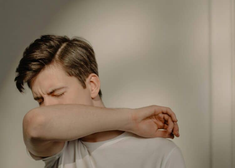 pexels-cottonbro-étudiant qui tousse dans son coude-Les 7 astuces de grands-mères pour guérir d’un rhume