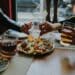 Pexels-Taha samet Arlsan-amis qui se partagent un plat et boivent un verre - 5 spots Food à Tester à Mons