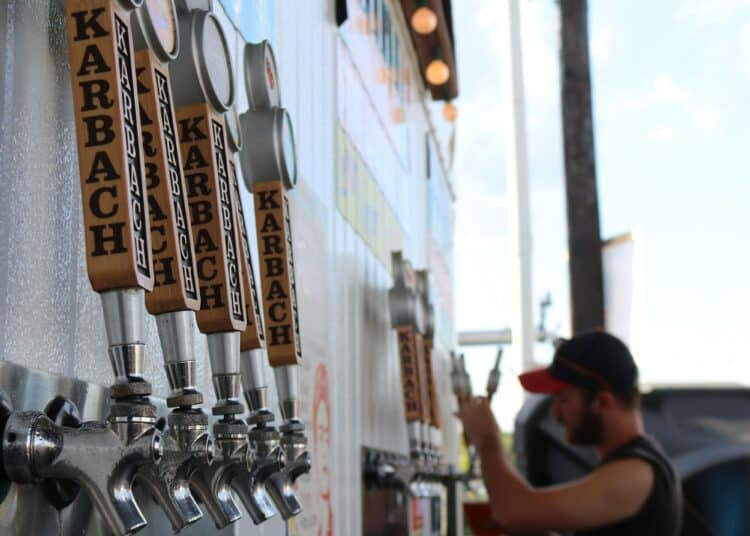 pexels-elevate-homme qui verse des bières au fût- Pourquoi faire bénévole en festival cet été ?