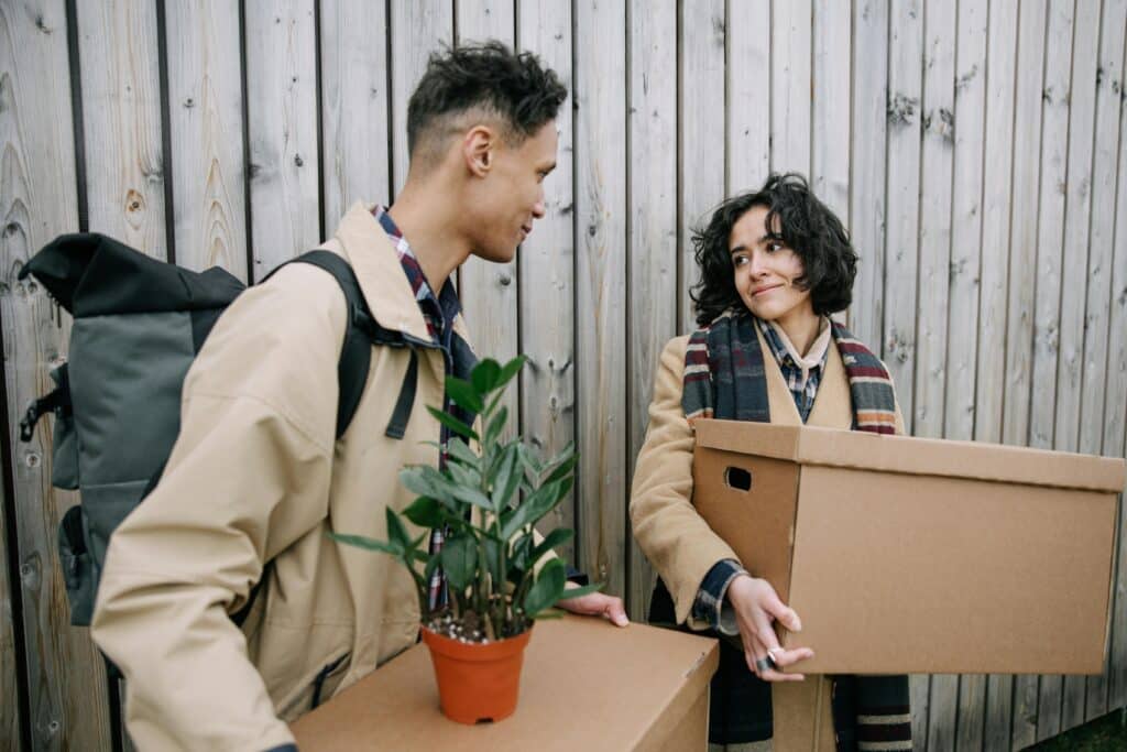 pexels-ivan-samkov-deux étudiant avec des cartons en main et des plantes-Quitter son kot pendant l’été, que faire de ses affaires ?