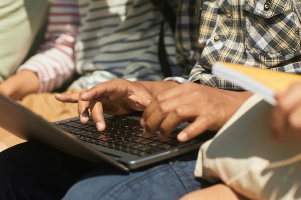 pexels-norma-mortenson-mains jeunes qui tapent à l'ordinateur-Pourquoi faire une lettre de motivation pour un job étudiant ?