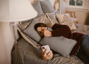 pexels-rdne-étudiante dans son lit qui regarde son téléphone pour lire un message-Pourquoi ghoster quelqu’un, c’est une mauvaise idée ?