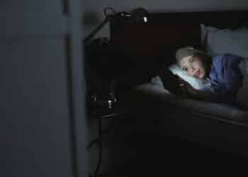 pexels-shvets-production-fille dans son lit avec son téléphone- La procrastination du sommeil, c'est quoi ?