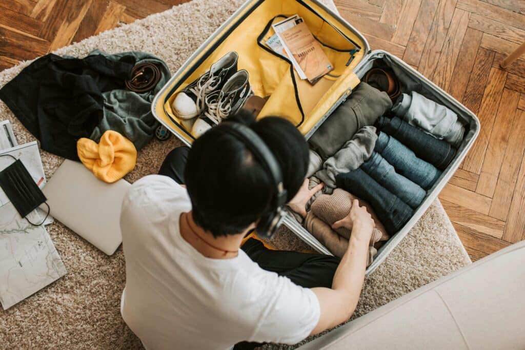 pexels-vlada-karpovich-jeune étudiant qui fait sa valise dans son kot-Que laisser dans son kot pour l’été ?