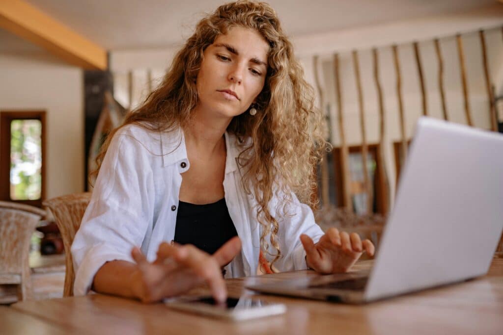 pexels-yankrukov-jeune étudiante sur son ordinateur et sur son téléphone-Quitter son premier job comment penser à l’avenir