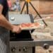 pexels-filirovska-personne qui met une pizza dans un barbecue-7 idées de repas pour un barbecue